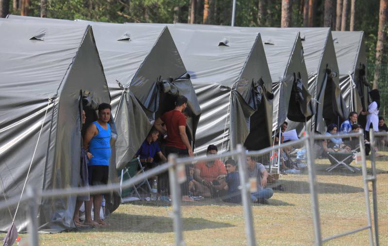 Migrants are seen outside tents at a camp near the border town of Kapciamiestis, Lithuania. AFP
