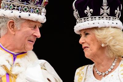 King Charles and Queen Camilla smile at each other on the balcony of Buckingham Palace. AFP