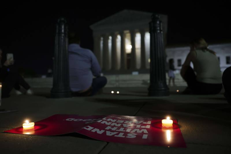 Demonstrators place candles outside the court. AFP