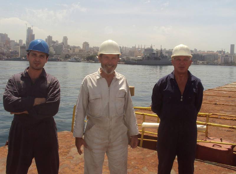 Boris Prokoshev, captain of cargo vessel Rhosus, centre, boatswain Boris Musinchak, left, and a crew member pose at the Beirut port in 2014. Boris Musinchak / Reuters