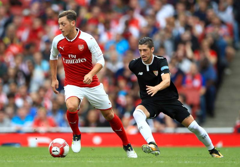 Arsenal's Mesut Ozil, left, in action during the Emirates Cup soccer match against Sevilla FC at the Emirates Stadium, London, Sunday, July 30, 2017. (John Walton/PA via AP)