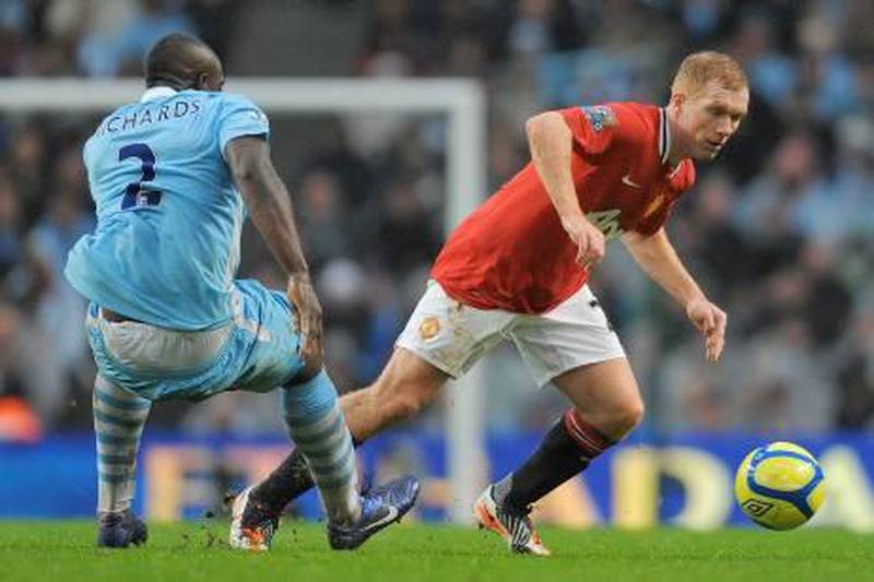 Manchester United's English midfielder Paul Scholes (R) vies with Manchester City's English defender Micah Richards (L) during the FA Cup third round football match between Manchester City and Manchester United at The Etihad stadium in Manchester, north-west England, on January 8, 2012.  AFP PHOTO / ANDREW YATES

RESTRICTED TO EDITORIAL USE. No use with unauthorized audio, video, data, fixture lists, club/league logos or “live” services. Online in-match use limited to 45 images, no video emulation. No use in betting, games or single club/league/player publications.
 *** Local Caption ***  599538-01-08.jpg
