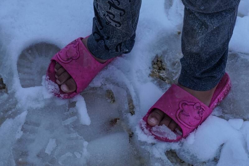 A child in the snow lacks waterproof shoes in Afrin, Aleppo