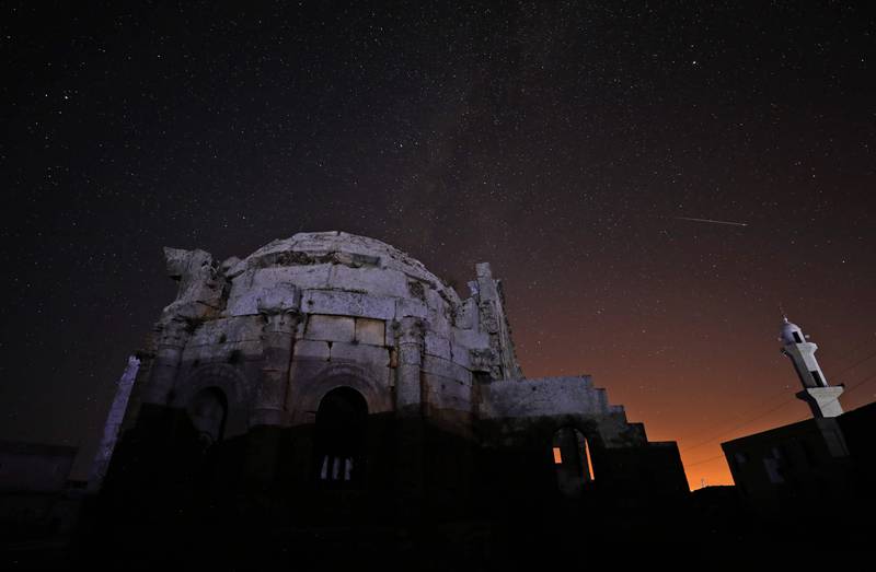 The Milky Way rises on July 29, 2022, above the 5th century basilica of Syria's Qalb Lozeh village in the northwestern Idlib province.  - The ancient lime-stone cathedral is the architectural forerunner of France's famed Notre Dame cathedral.  The abandoned church is widely hailed as Syria’s finest example of Byzantine-era architecture and is considered to have inspired Romanesque and Gothic cathedrals in Europe, including the Paris landmark.  (Photo by OMAR HAJ KADOUR  /  AFP)