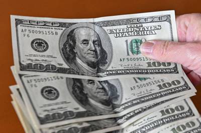 The US dollar is expected to fall further against key currencies over the next six to 12 months, according to UBS. AFP