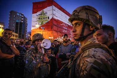 Lebenese soldiers keep watch as several hundred people protest in the northern city of Tripoli on April 17, 2020 despite the country's coronavirus lockdown, marking six months since the country was rocked by mass rallies over government corruption and economic hardships. / AFP / Ibrahim CHALHOUB