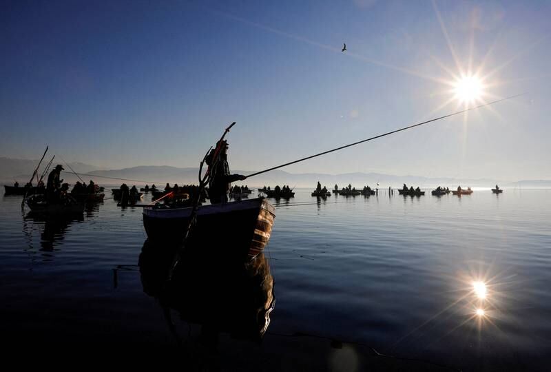 Early morning fishermen on their boats at Dojran Lake, in Dojran, North Macedonia. Once almost dried up, the lake is now a thriving nature reserve. Reuters