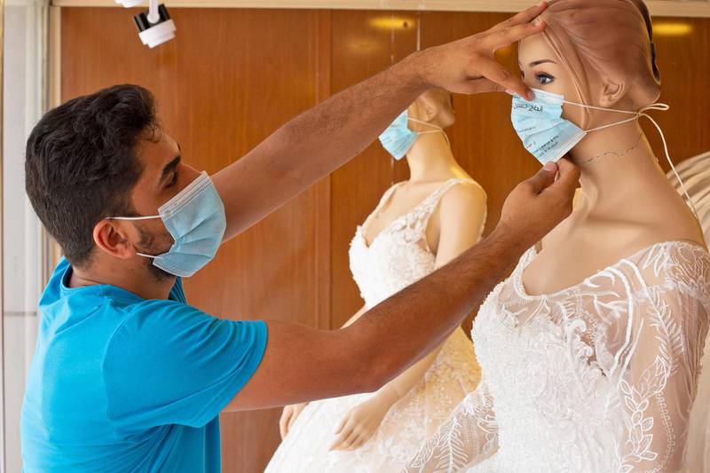 Iraqi printing business owner Hossam al-Aidani adjusts a protective mask bearing a wedding invitation on a bridal shop mannequin amid the COVID-19 pandemic, in the southern port city of Basra. Al-Aidani's small business almost closed-down due to the restrictions amid the novel coronavirus crisis. But his idea to print invitations on protective masks allowed its survival, selling 50 per wedding, especially in the Shiite-majority southern Iraq, where marriage celebrations are to be held before the beginning of the Muslim mourning month of Muharram, at the end of August.  AFP