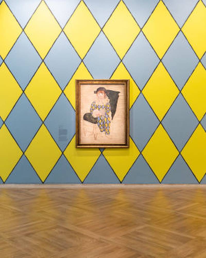 Paul as Harlequin (1924) on a harlequin painted wall. Photo: Picasso Museum / Paul Smith