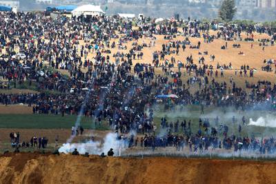 Israeli soldiers fire tear gas from the Israeli side of the Israel-Gaza border as Palestinians protest on the other side on March 30, 2018. Amir Cohen / Reuters