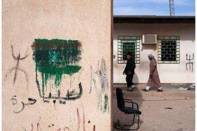 Near the Dehiba border on the Libyan side, pro-rebel graffiti is prevalent, along with the Amazigh symbol, seen here to the left and right of the rebel flag. Lindsay Mackenzie for The National