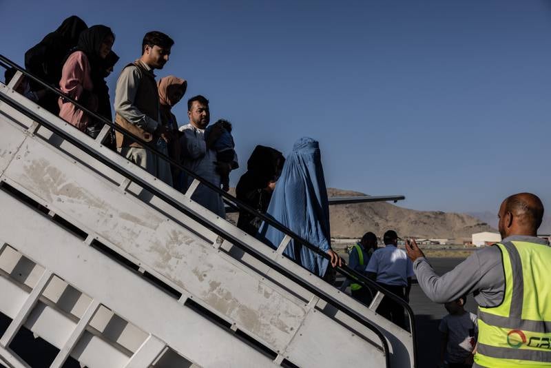 People disembark from the Ariana Afghan Airlines flight that landed from Herat. Stefanie Glinski for The National