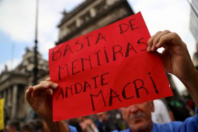A man holds up a sign that reads "Enough of lies, (Argentine President) Macri leave" during a protest against the government's austerity measures outside the Congress in Buenos Aires, Argentina September 17, 2018. REUTERS/Marcos Brindicci