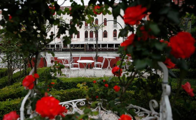 Rose bushes frame an empty garden overlooking a canal at the Ca' Nigra lagoon resort hotel along the canal grande in Venice, Italy.  AP Photo / Antonio Calanni