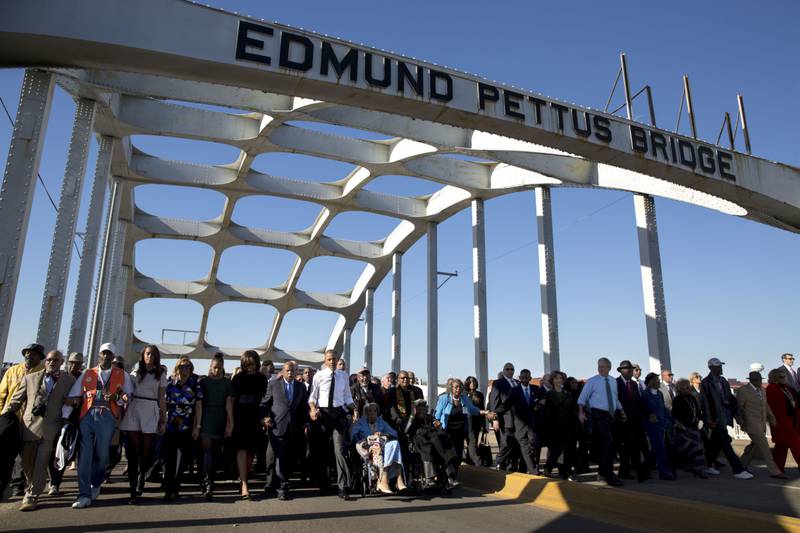 Mr Obama, wife Michelle, her mother, daughters Malia and Sasha join John Lewis, George W Bush, his wife Laura and other dignitaries to march across the Edmund Pettus Bridge to commemorate the 50th Anniversary of Bloody Sunday, March 7, 2015. Photo courtesy of the National Archives
