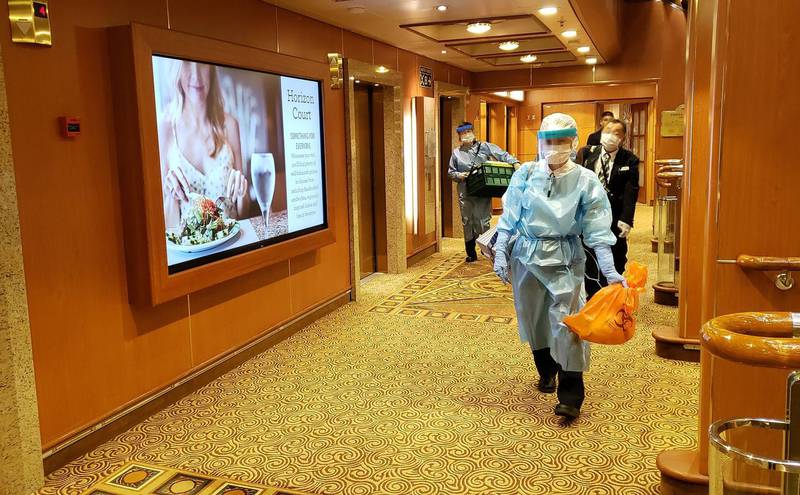 Healthcare workers walk through the decks of the Diamond Princess cruise ship, the vessel carrying 3,711 people sits in the port of Yokohama. At least 10 people on the cruise ship quarantined off the coast of Japan have tested positive for the new coronavirus, Japan's health minister said. AFP