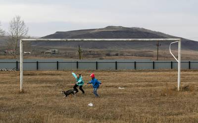 Children play with a puppy near a goalpost on a football pitch in the Siberian settlement of Novosyolovo, Krasnoyarsk region, Russia. Ilya Naymushin / Reuters
