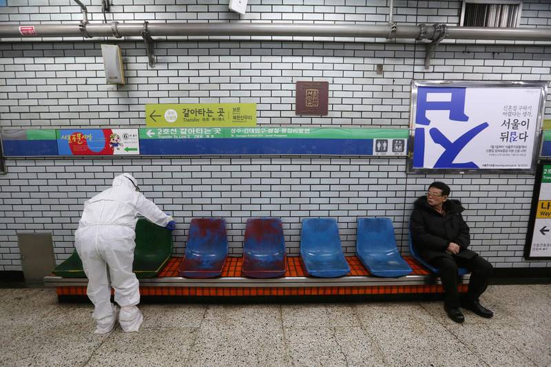 A worker wearing protective gears disinfect chairs as a precaution against the coronavirus at a subway station in Seoul. AP Photo