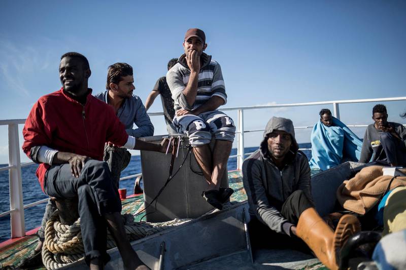 Migrants sit on the deck of the Nuestra Madre de Loreto Spanish fishing vessel carrying 12 migrants rescued off the coast of Lybia on Friday, Nov. 30, 2018. Meanwhile, Spanish officials say they have rescued about 650 migrants from 16 boats crossing the Mediterranean from North Africa to Europe on Thursday, finding one dead woman among them. (AP Photo/Javier Fergo)