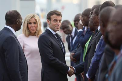 France's President Emmanuel Macron shakes hands as he is greeted by Ivory Coast's President Alassane Ouattara (L) next to his wive Brigitte Macron (2L) upon their arrival at the Felix Houphouet Boigny International Airport in Abidjan at the start of a three day visit to West Africa.   AFP