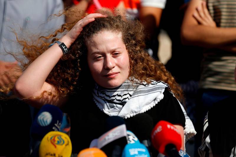 Palestinian activist and campaigner Ahed Tamimi speaks during a press conference on the outskirts of the West Bank village of Nabi Saleh on July 29, 2018, upon her release from prison after an eight-month sentence. Tamimi, 17, and her mother Nariman arrived in their village of Nabi Saleh in the occupied West Bank, where they were met by crowds of supporters and journalists. / AFP / ABBAS MOMANI
