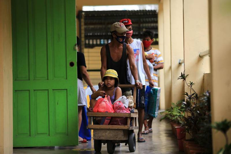 Residents carrying their belongings arrive at an evacuation center in Legaspi, Albay province. AFP