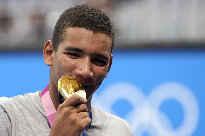 Ahmed Hafnaoui, of Tunisia, poses with his gold medal he won in the final of the Men's 400m Freestyle on day two of the Tokyo 2020 Olympic Games.