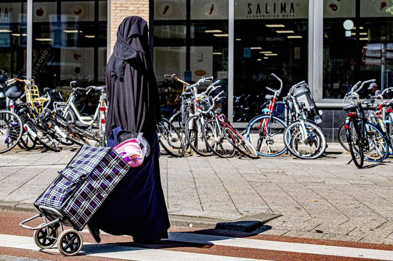 A woman wearing a Niqab Islamic dress, pulls a shopping trolley along a street in Rotterdam on July 29, 2019.   The Netherlands banned the wearing of a face-covering veil, such as a burqa or niqab, in public buildings and on transport from on August 1, 2019, as a contentious law on the garment worn by some Muslim women came into force. Between 200 and 400 women are estimated to wear a burqa or niqab in the country of 17 million people.
 - Netherlands OUT
 / AFP / ANP / ROBIN UTRECHT
