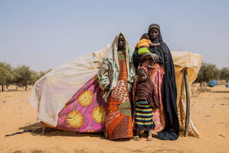 6. MaliAigachatou, a single mother and her children, standing in front of their makeshift tent after fleeing violence in Timbuktu in Mali.Photo: Togo Moise/NRC