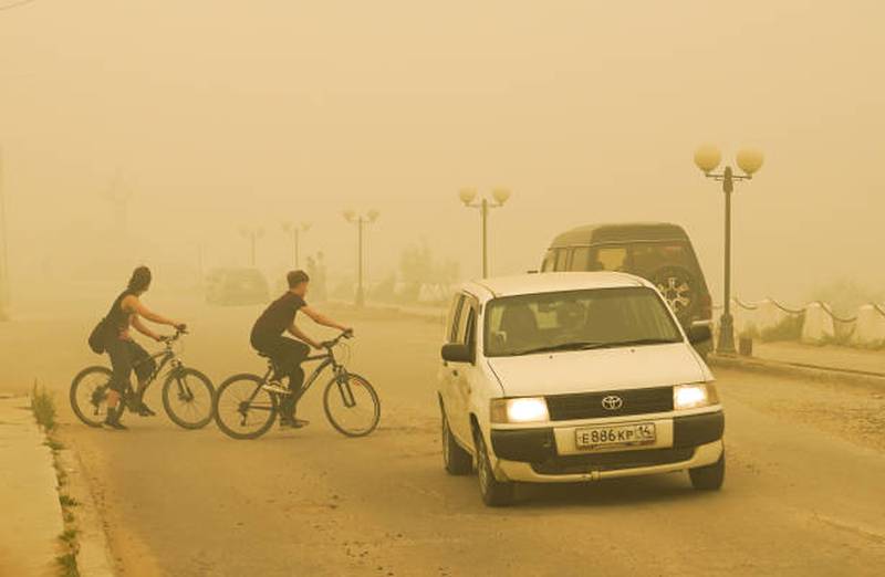 Cyclists ride through thick wildfire smoke in Yakutsk, Russia. Health chiefs are calling for action to protect both the planet and public health. Getty