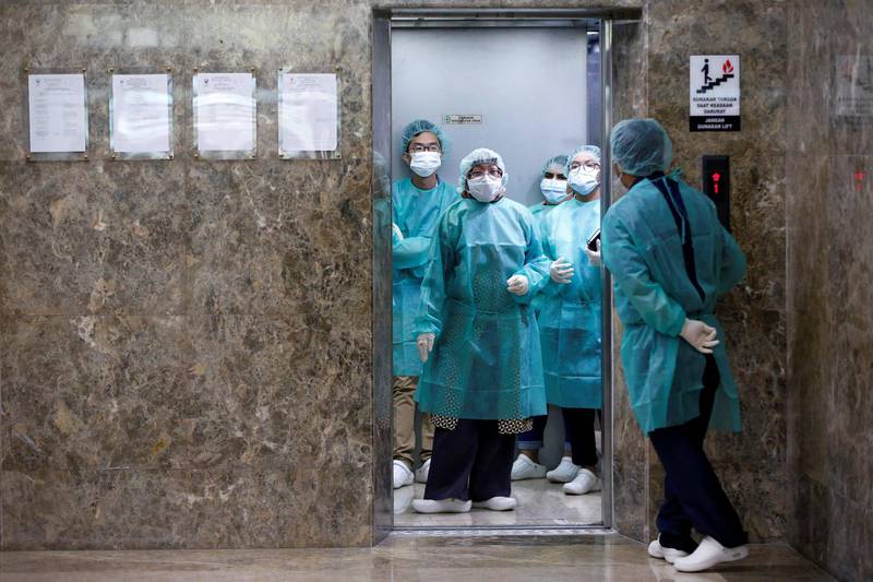 Journalists wear protective suits inside an elevator as they prepare for a media visit to Indonesian Health Ministry's Laboratorium for Research on Infectious-Diseases, following the outbreak of the new coronavirus in China, in Jakarta, Indonesia. Reuters