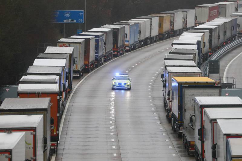 A police car passes trucks parked on the M20 motorway in Operation Stack near Ashford, U.K., on Monday, Dec. 21, 2020. Britain's biggest port stopped all traffic heading to Europe, triggering delays to food supplies after the discovery of a new variant of the virus prompted a wave of countries to ban travel from the U.K. Photographer: Chris Ratcliffe/Bloomberg