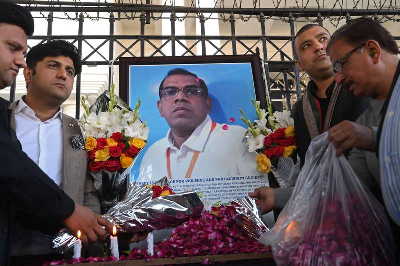 Pakistani businessmen pay tribute beside a photograph of a Sri Lankan factory manager in Sialkot who was beaten to death and set ablaze by a mob who accused him of blasphemy. Photo: AFP