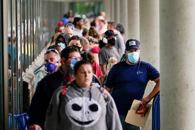 FILE PHOTO: Hundreds of people line up outside a Kentucky Career Center hoping to find assistance with their unemployment claim in Frankfort, Kentucky, U.S. June 18, 2020. REUTERS/Bryan Woolston/File Photo