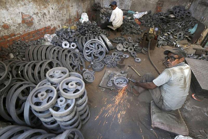 Workers grind iron bearings used in textile machinery inside a factory on the outskirts of the western Indian city of Ahmedabad on May 12, 2014. The country is on the cusp of political change that is widely expected to script an economic revival. Amit Dave / Reuters