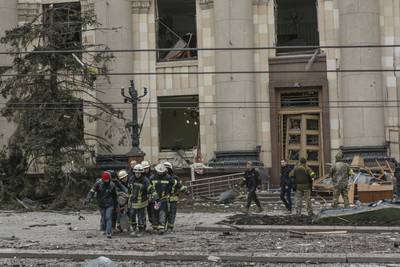 Ukrainian emergency service personnel carry the body of a victim following shelling in Kharkiv. AP