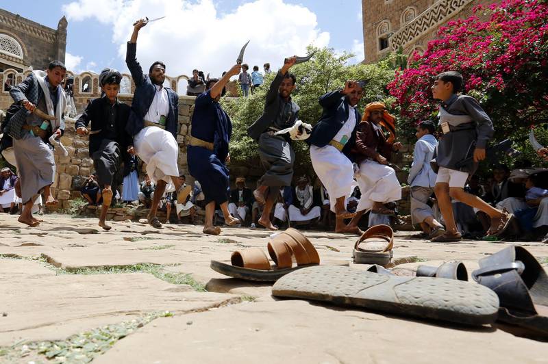 Yemenis perform a traditional dance to celebrate the Eid al-Fitr at a tourist site on the outskirts of Sanaa, Yemen.  EPA