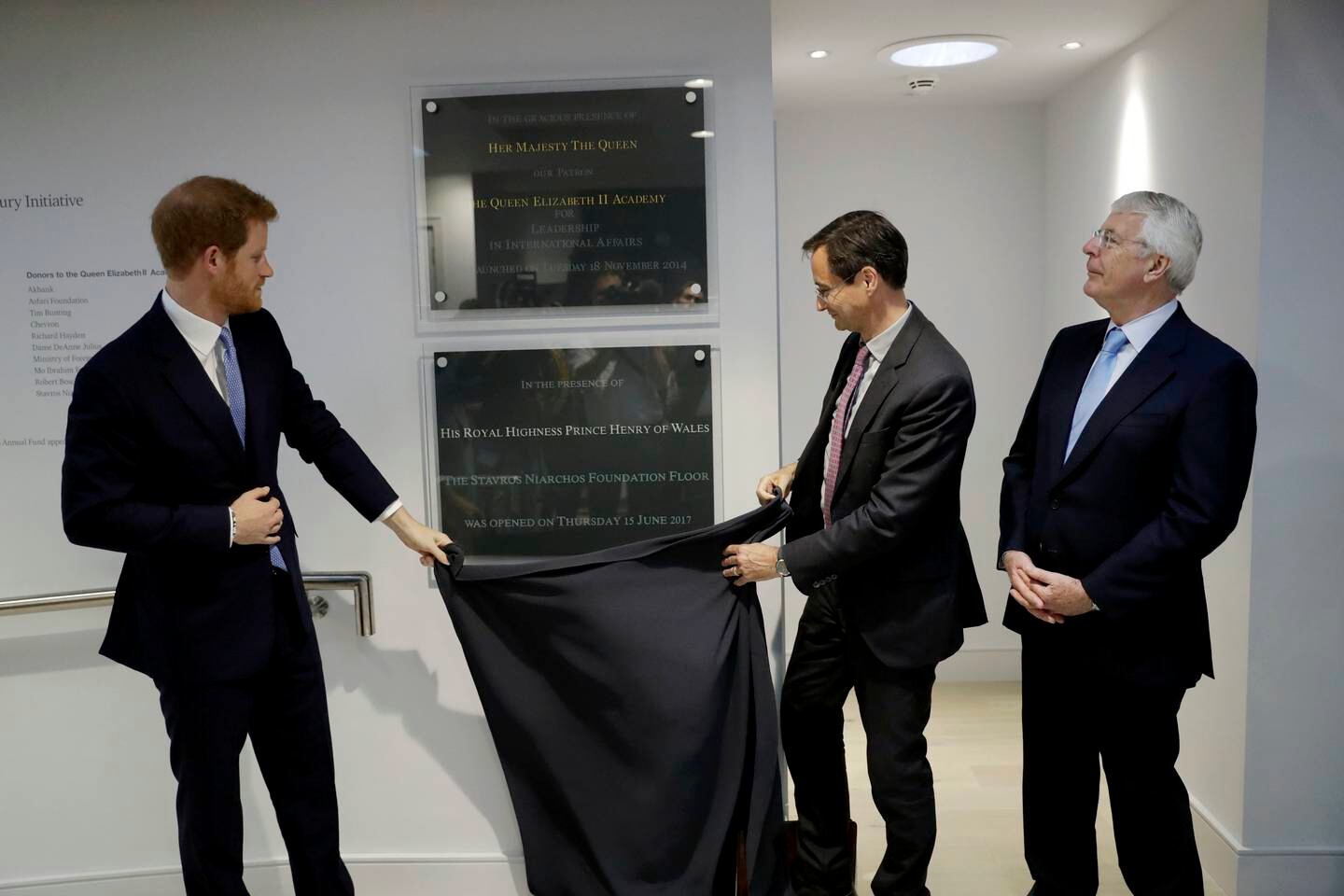 Britain's Prince Harry unveils a plaque with Robin Niblett, and former British prime minister John Major, right, during a visit to Chatham House in 2017. Getty 