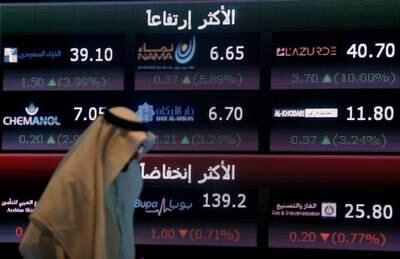 FILE PHOTO: An investor walks past a screen displaying stock information at the Saudi Stock Exchange (Tadawul) in Riyadh, Saudi Arabia June 29, 2016. REUTERS/Faisal Al Nasser/File Photo