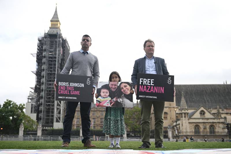 Richard Ratcliffe and Gabriella hold placards in Parliament Square. Nazanin Zaghari-Ratcliffe  was taken into custody at Tehran airport in April 2016. AFP