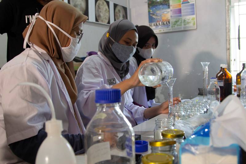 Volunteers examine the contents of microplastics found in a river water sample. at the laboratory owned by Indonesia's environmental activist group Ecoton.