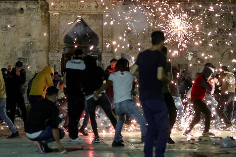 Palestinians react as Israeli police fire stun grenades during clashes at the Jerusalem compound that houses Al Aqsa Mosque, on May 7, 2021. Reuters