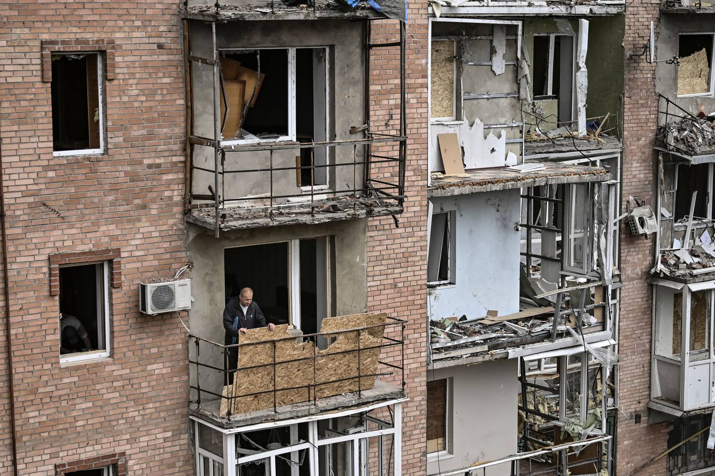 A man stands on the balcony of his destroyed apartment in Bakhmut, Donbas. AFP