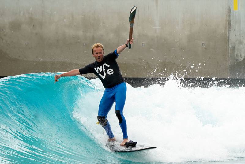Founder of the Wave, Nick Hounsfield, holds the baton as he surfs at the centre in Bristol. PA