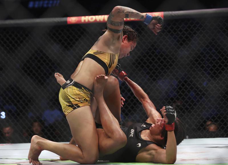 Amanda Nunes, top, goes to strike Julianna Pena during their bantamweight title bout at UFC 277. AP