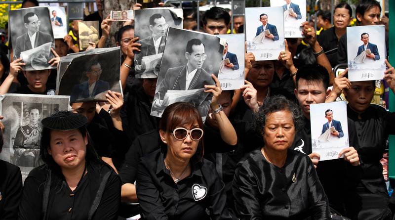 Mourners hold aloft the portraits of late Thai King Bhumibol Adulyadej during his funeral procession and royal cremation ceremony, in Bangkok. Sakchai Lalit / AP Photo.