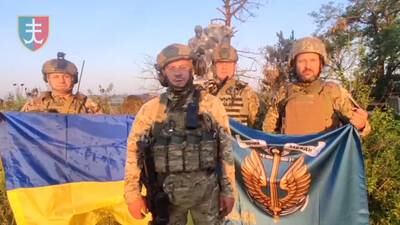 Ukrainian soldiers stand with Ukrainian flag in Urozhaine, Donetsk Region, eastern Ukraine, in August. Reuters