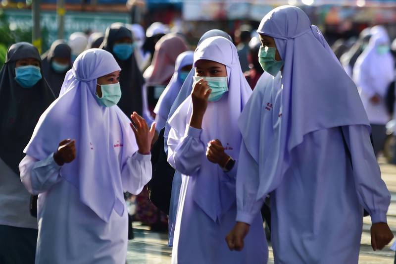 Students wearing face masks talk in the Attarkiah Islamic School in the southern Thai province of Narathiwat as schools across Thailand reopened after being temporarily closed to concerns about the novel coronavirus. AFP