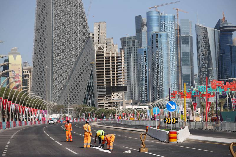 This way for the World Cup. Workers paint directions on the road in Doha. AFP
