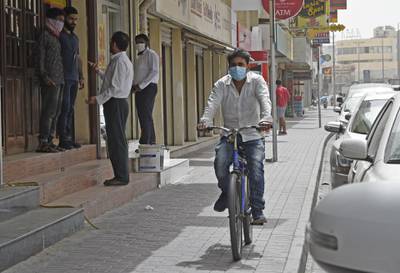 People wearing protective masks are seen on a street in the centre of the Bahraini capital Manama.  AFP